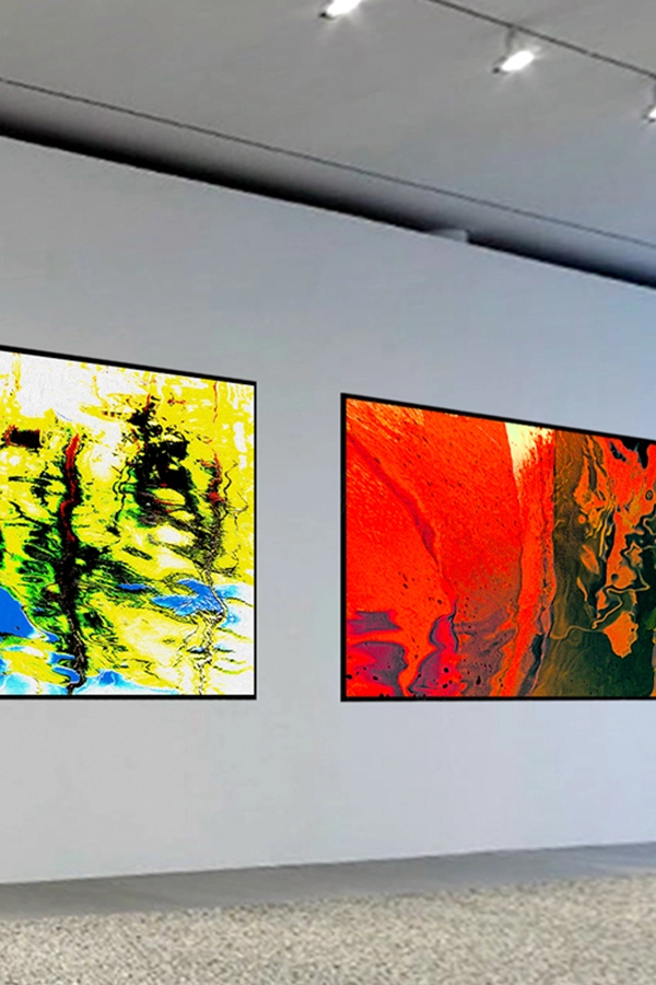 Two vibrant abstract paintings displayed on a gallery wall, featuring splashes of yellow, green, red, and blue colors
