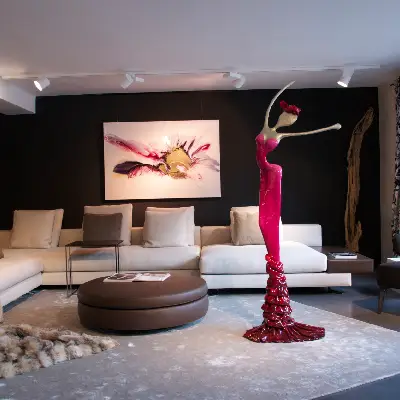 A spacious living room featuring a large sofa and an oversized painting on the wall.